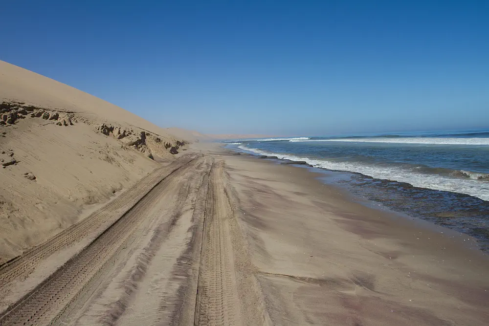 Colossal sand dunes of the Namib Desert meeting the crashing waves of the Atlantic Ocean