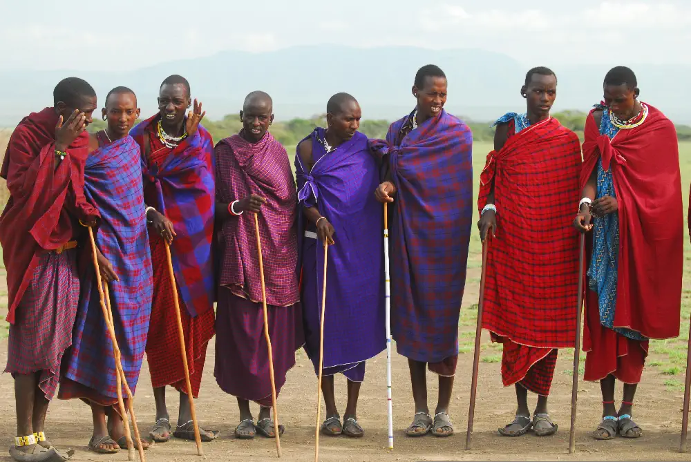 Traditional Maasai people in vibrant red shúkà attire standing in the East African rift valley